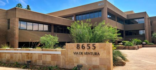 Office building exterior with sign reading 8655 Via De Ventura.