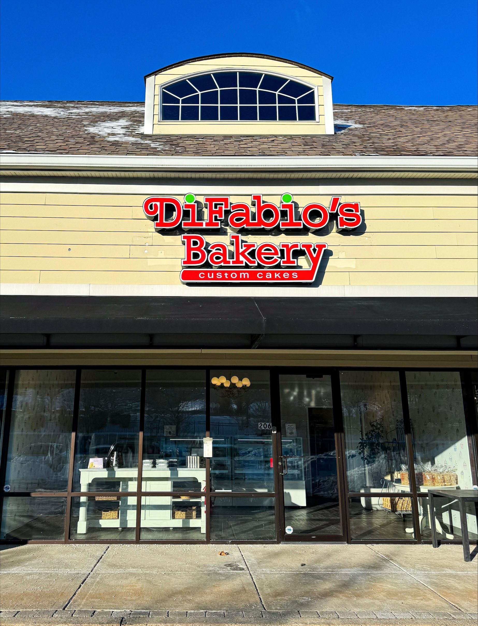DiFabio's Bakery storefront with red sign and glass entrance under a striped awning