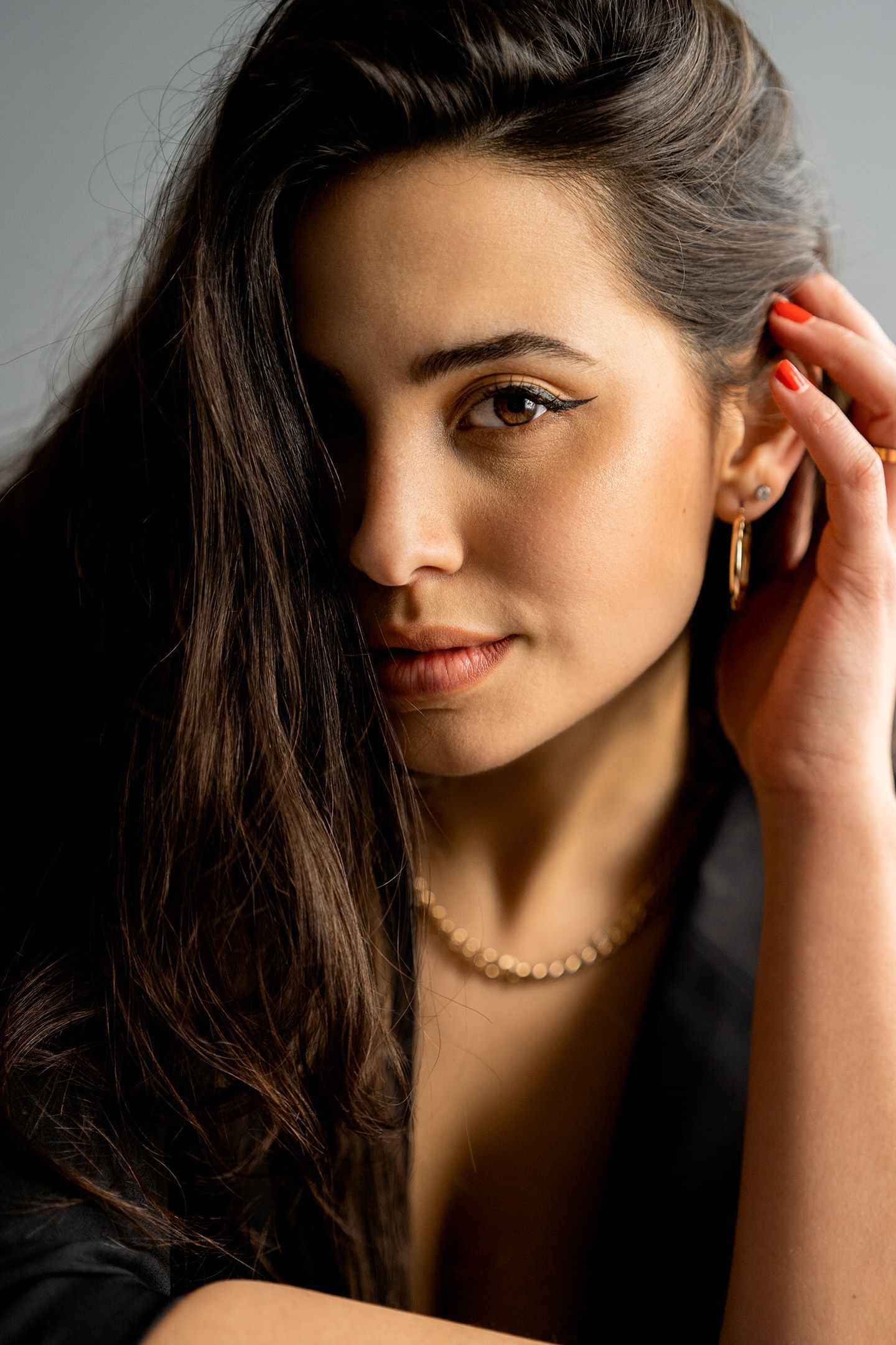 A close up of a woman wearing a necklace and earrings.