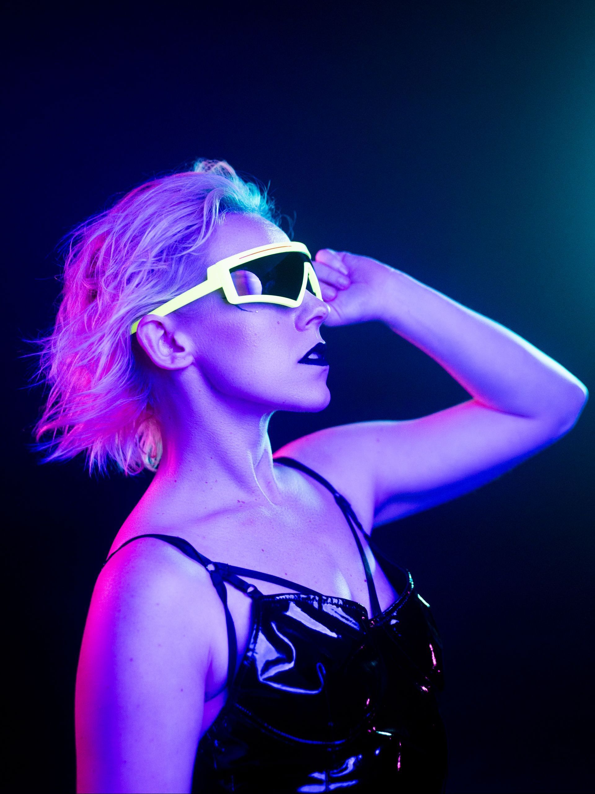 A portrait of a woman with colorful pink and blue studio lighting