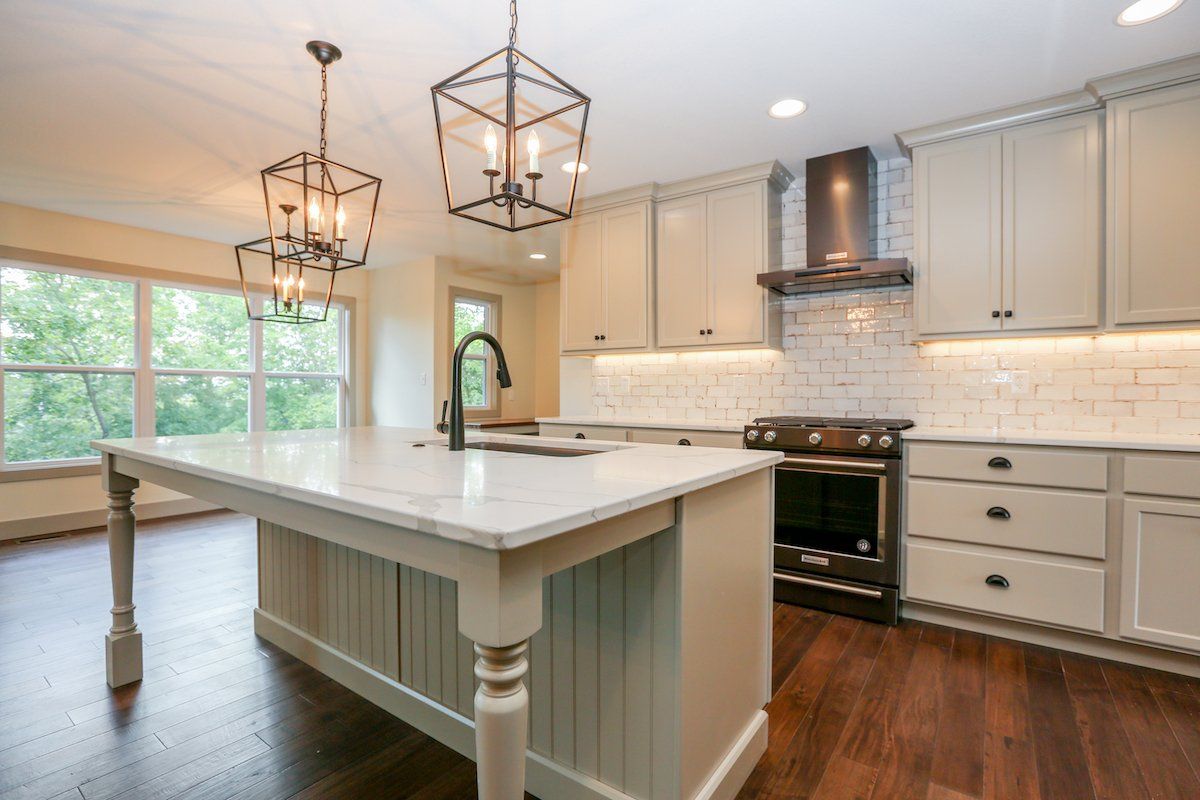 A Beautiful Kitchen by Hansman Custom Homes in Columbia, MO With a Marble Island & Overhead Lights.