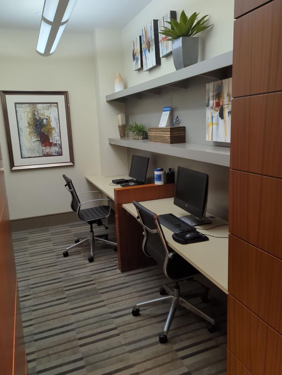 A room with two desks with computers on them