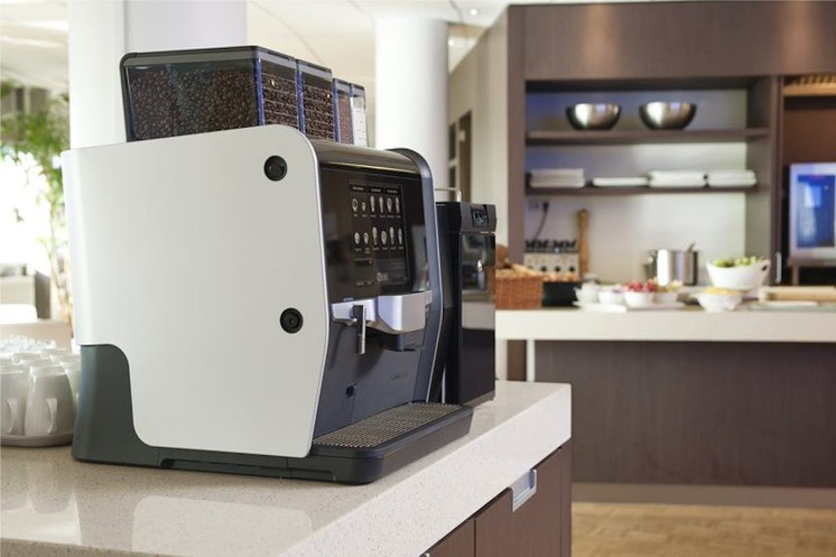 A coffee machine is sitting on a counter in a kitchen.