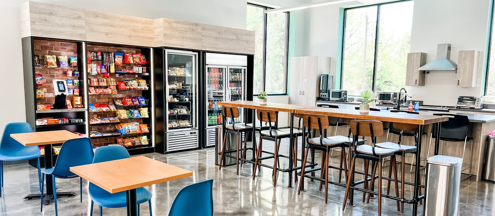A dining room with tables and chairs and a vending machine.
