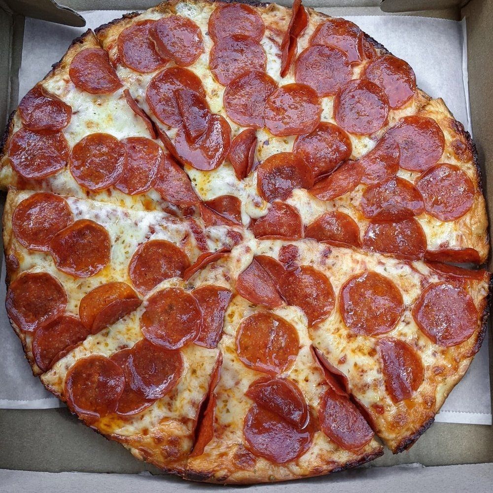 Pepperoni pizza, sliced into eight pieces, in a cardboard box.