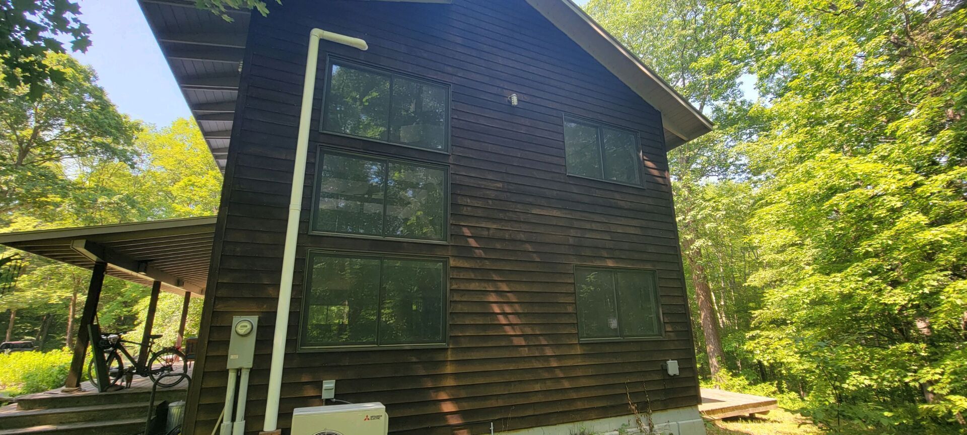 A small log cabin in the middle of a forest surrounded by trees.