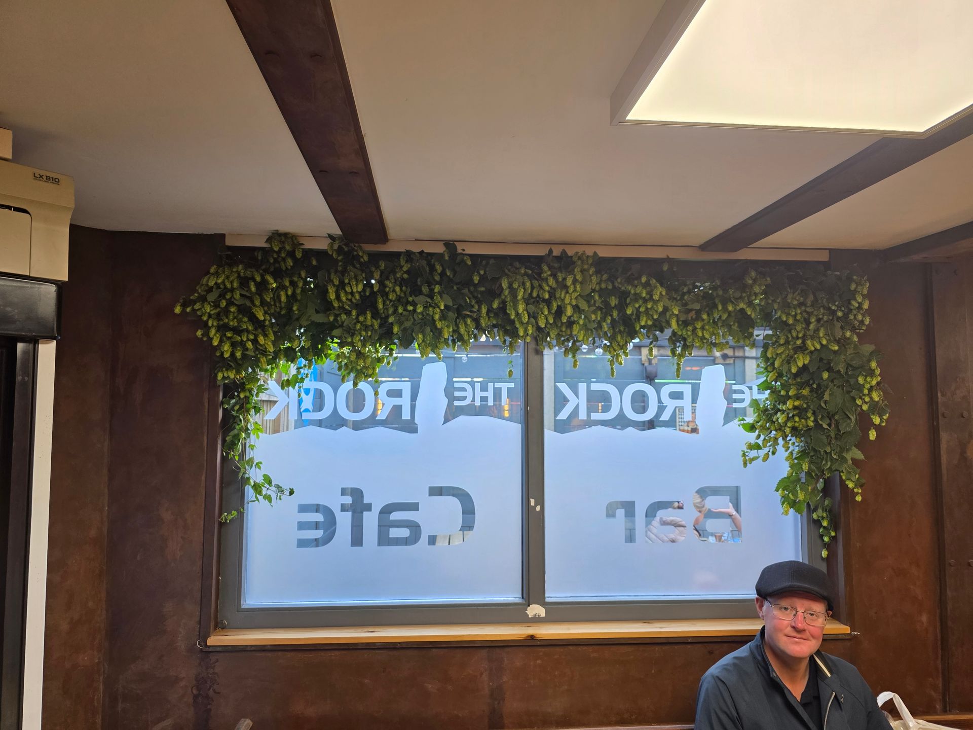 Man at a cafe bar with frosted window displaying