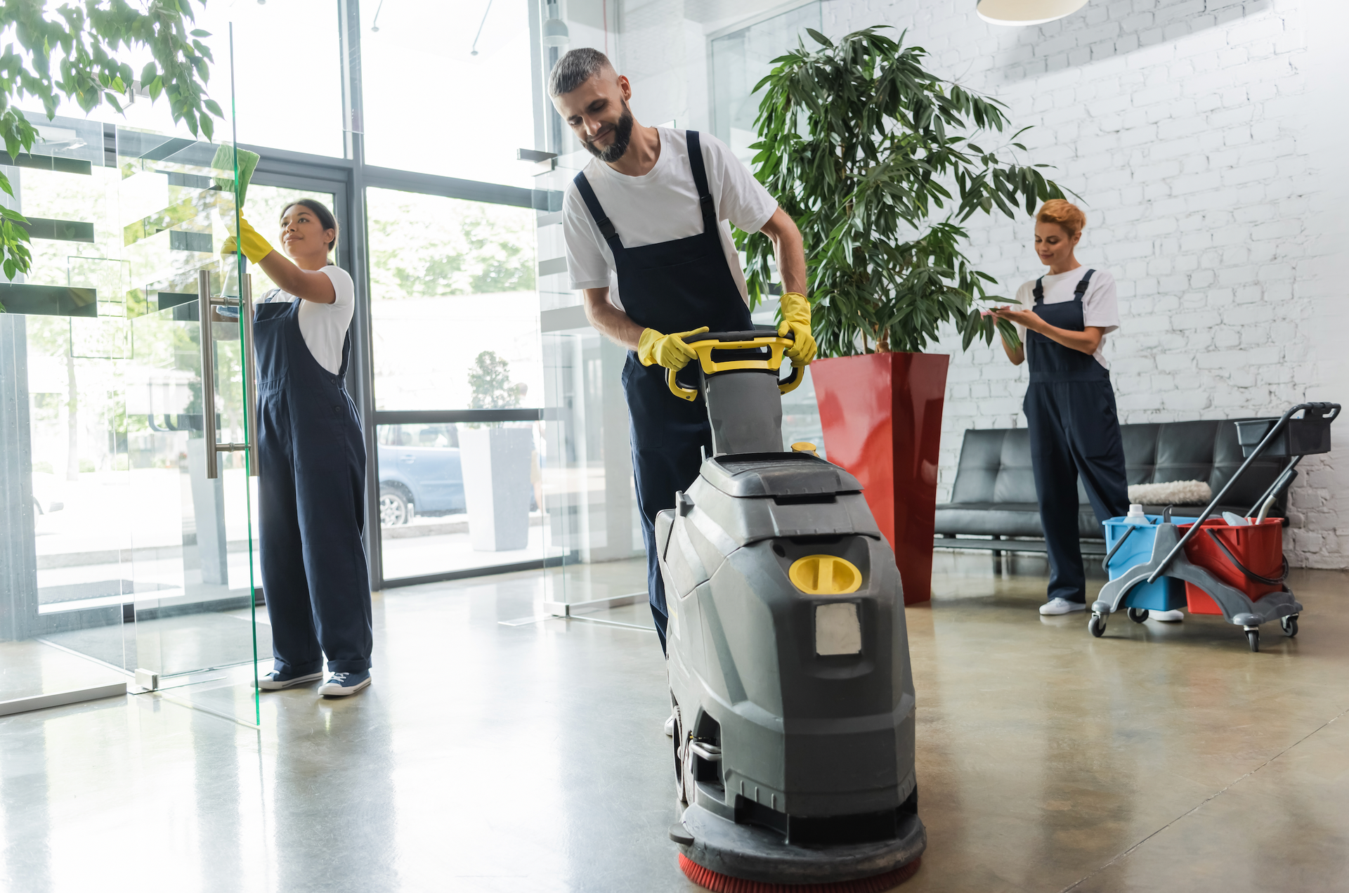 A man is using a machine to clean the floor in an office.