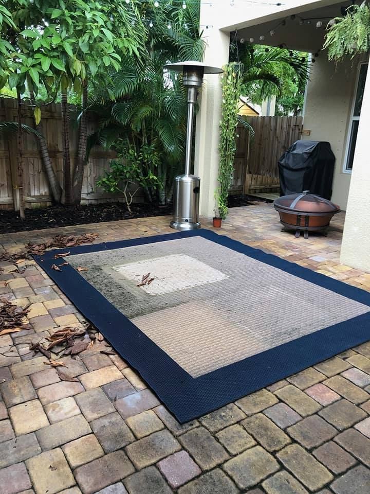 Outdoor patio with a rug, patio heater, and a fire pit on brick pavers.