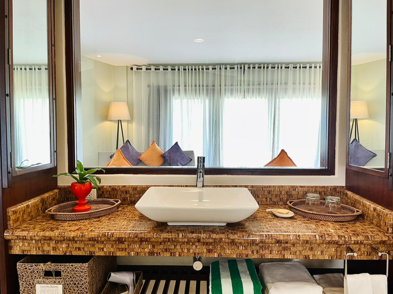 Bathroom vanity with granite counter, white vessel sink, and mirror reflecting a bright room beyond