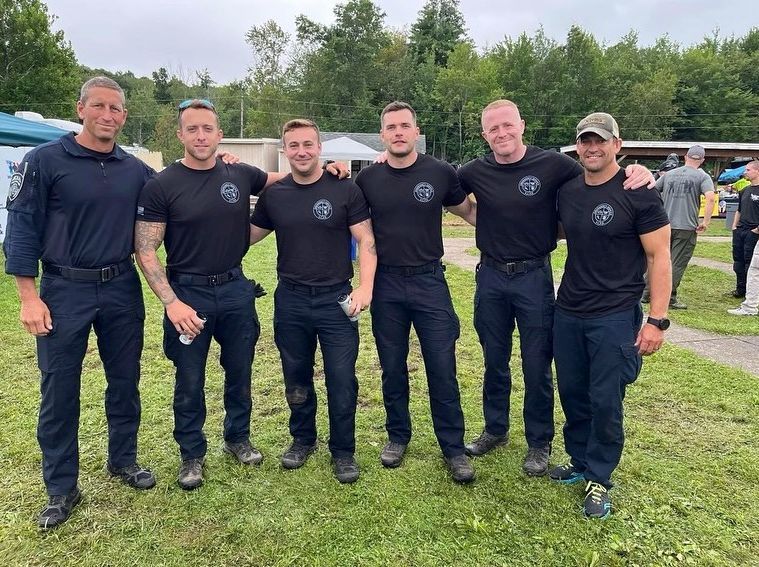 A group of men are posing for a picture in a field.