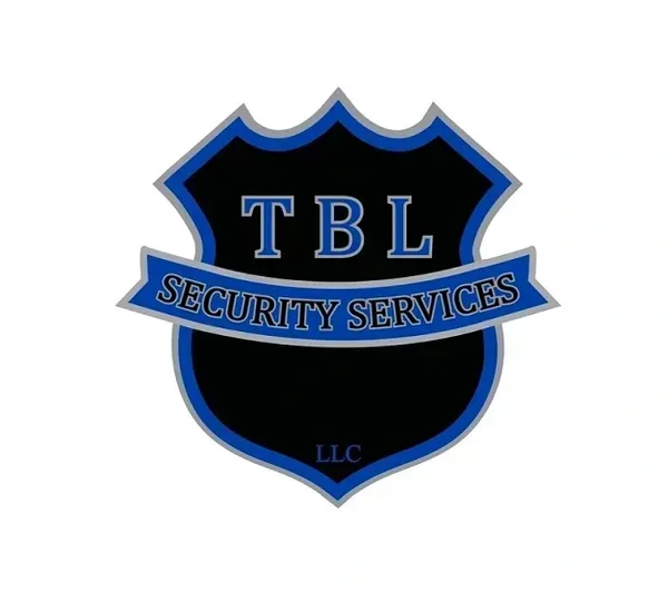 A black shield logo with a blue outline, featuring the letters