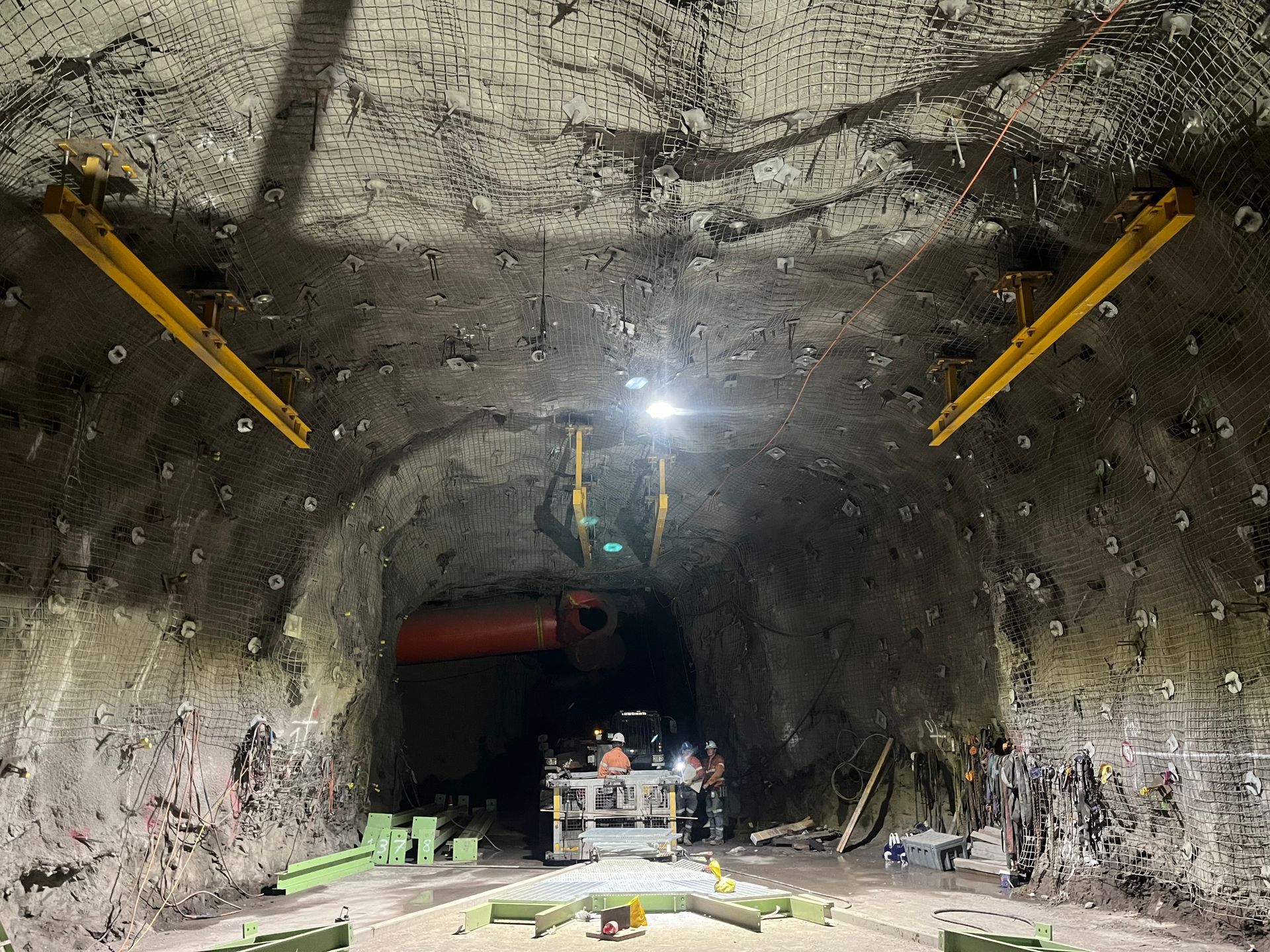 Inside a Rough Rock Tunnel, Workers and Machinery Sit Under Bright Lights — Vent Doors Australia in Bohle, QLD