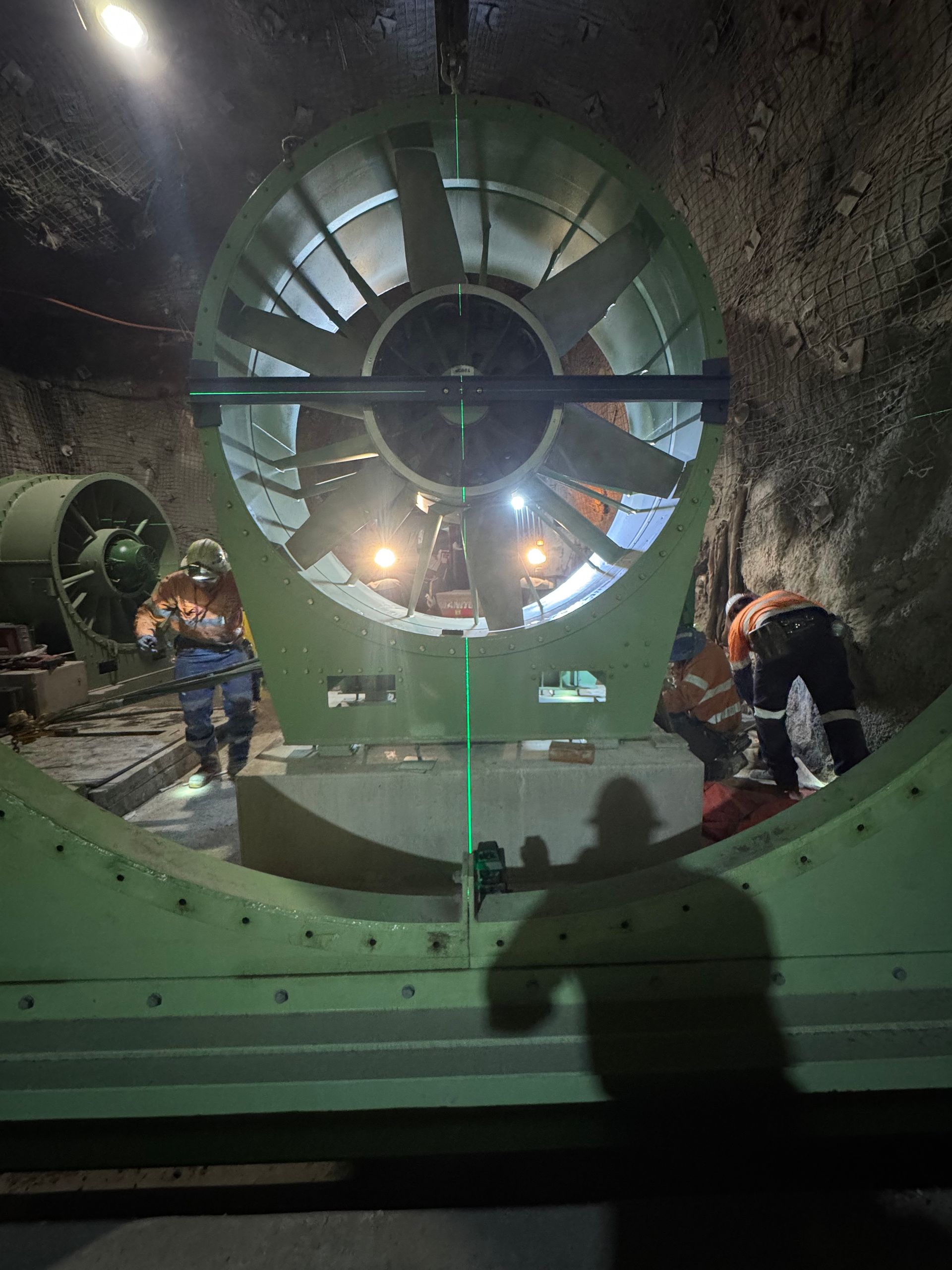 People standing by a large illuminated tunnel fan inside an industrial facility — Vent Doors Australia in Bohle, QLD