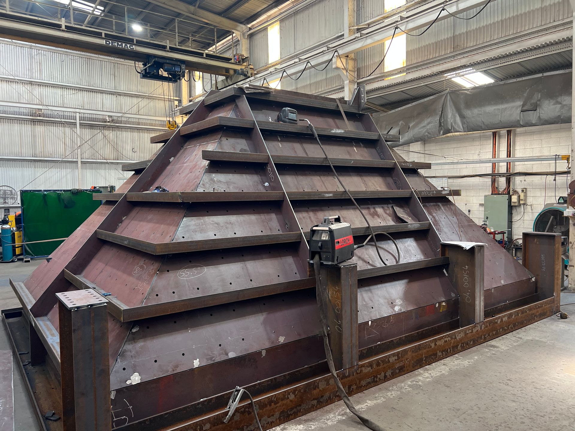Large industrial metal machine with sloped panels inside a factory workshop — Vent Doors Australia in Ryan, QLD