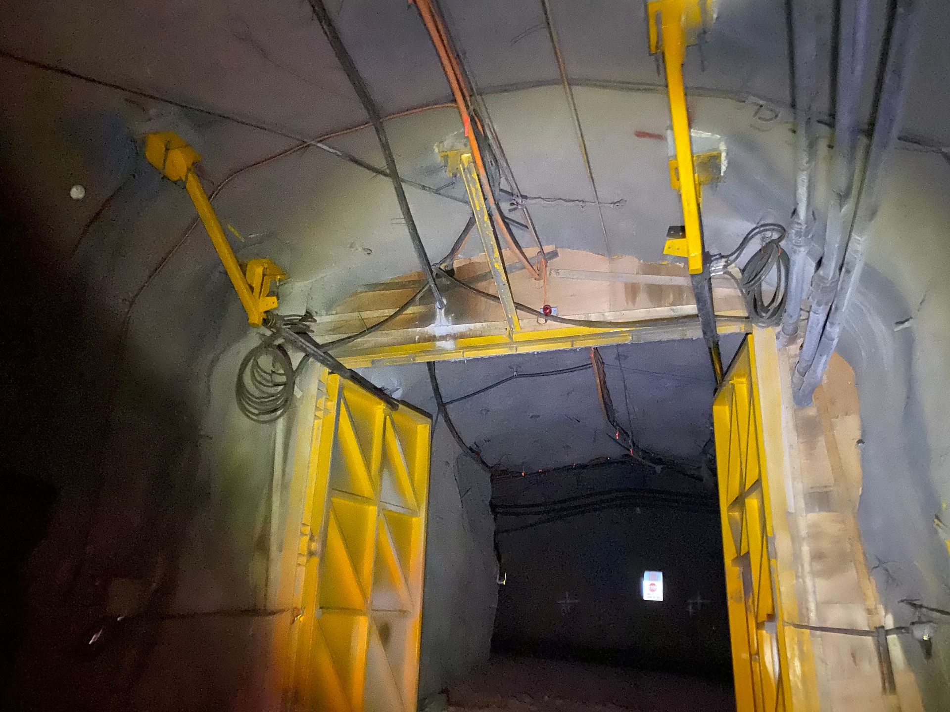 Industrial tunnel entrance with yellow braces and a dark passage leading into the distance — Vent Doors Australia in Bohle, QLD