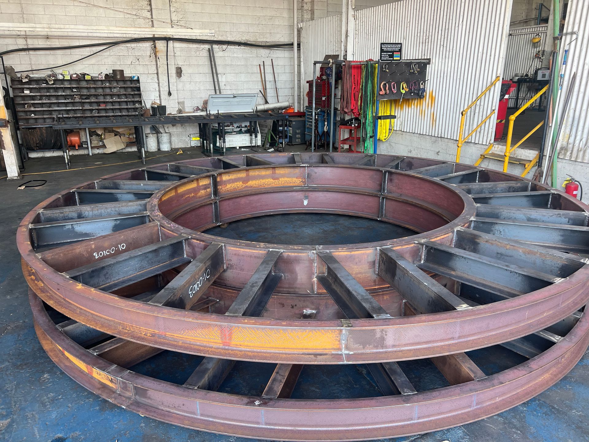 Large Rust-colored Metal Wheel Frame in an Industrial Workshop — Vent Doors Australia in Bohle, QLD