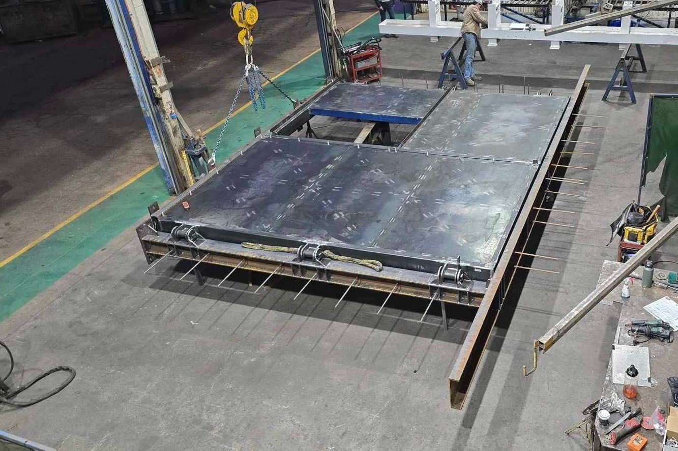 Rows of white metal pipe flanges arranged on a factory floor in an industrial workshop — Vent Doors Australia in Ryan, QLD