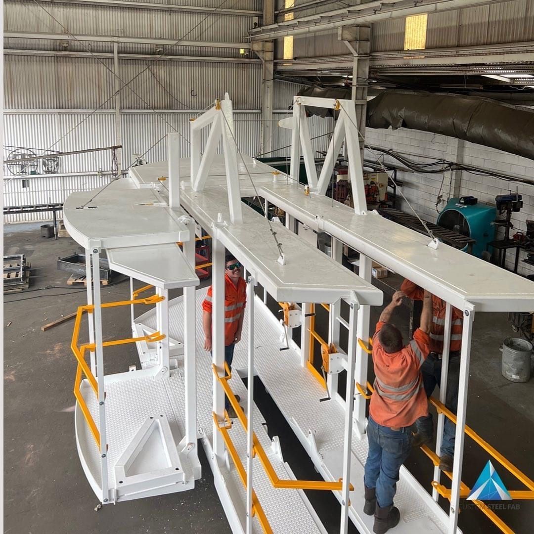 Two Workers Assembling a Large White Industrial Structure Inside a Warehouse — Vent Doors Australia in Bohle, QLD