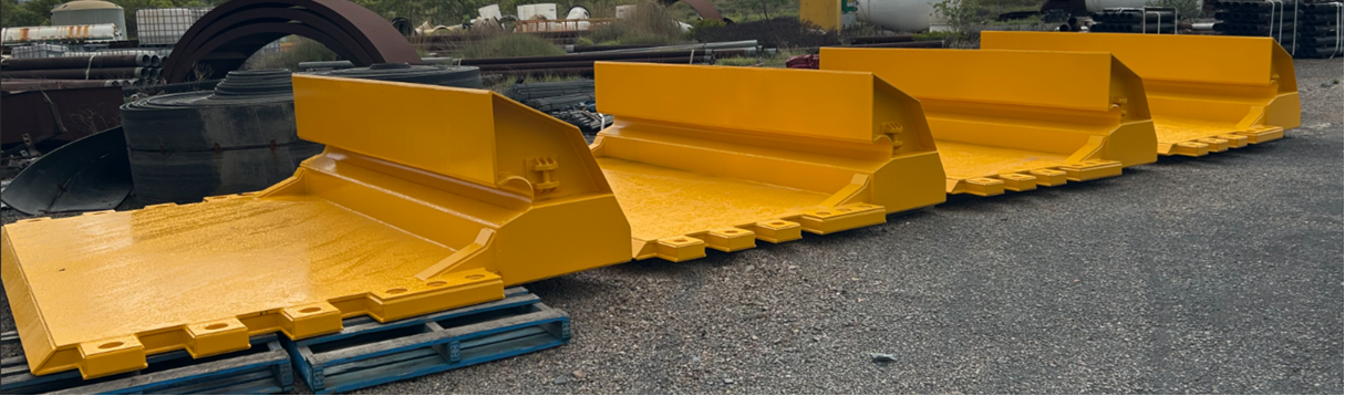 Bright Yellow Industrial Snowplow Blades Lined Up on a Gravel Lot — Vent Doors Australia in Bohle, QLD