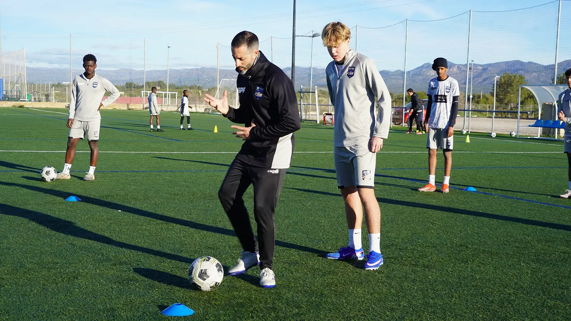 Soccer players practicing dribbling drills on a sunny outdoor field