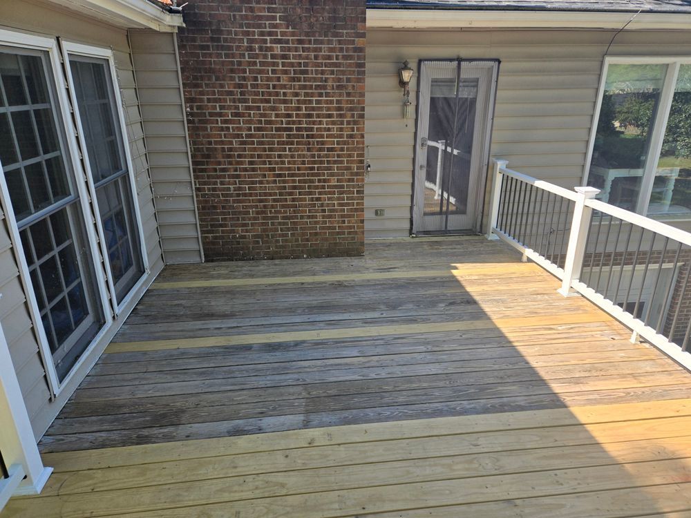 Wooden deck with brick chimney and house with a door and windows.
