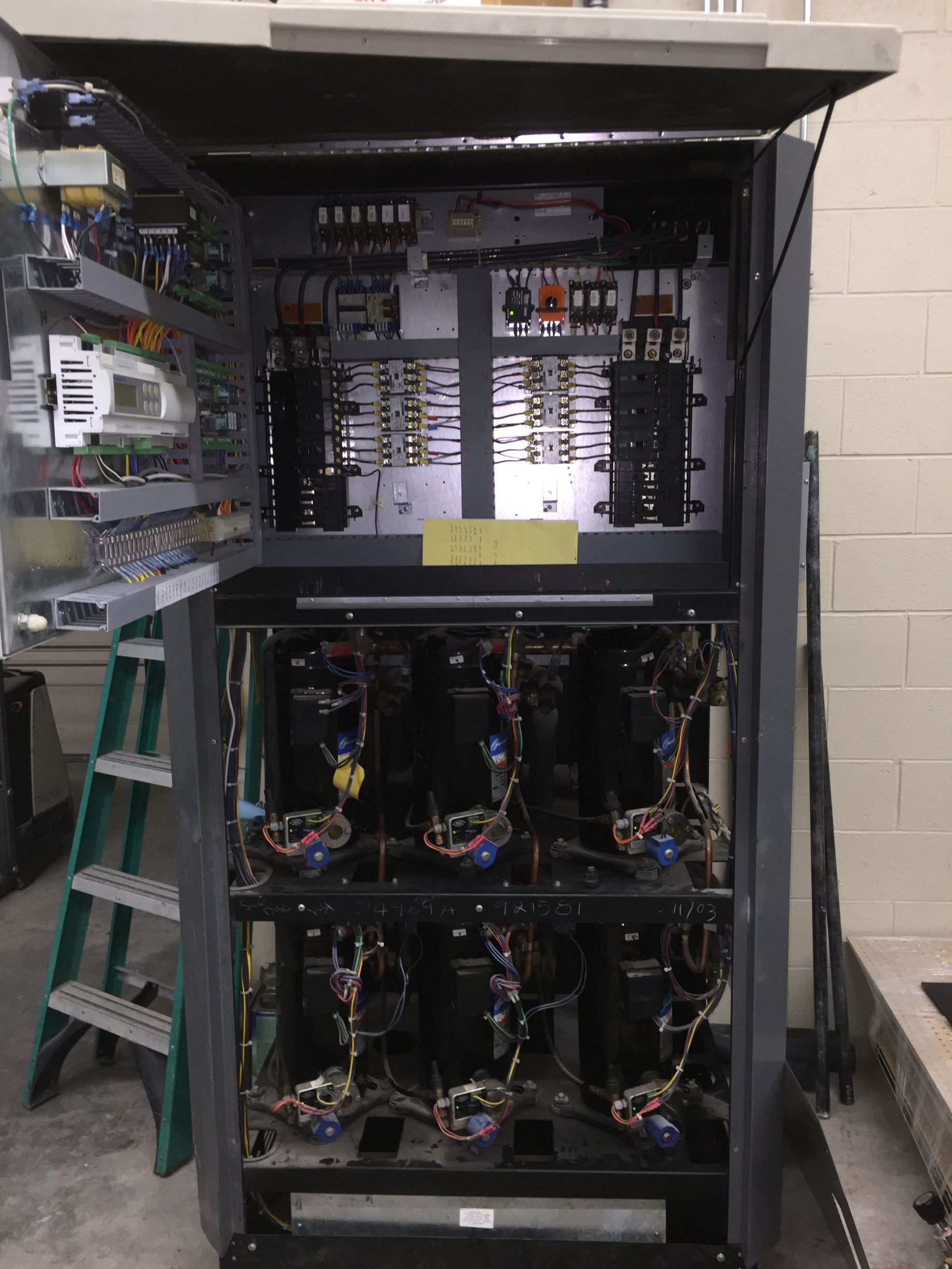 A large electrical cabinet with a ladder in the background