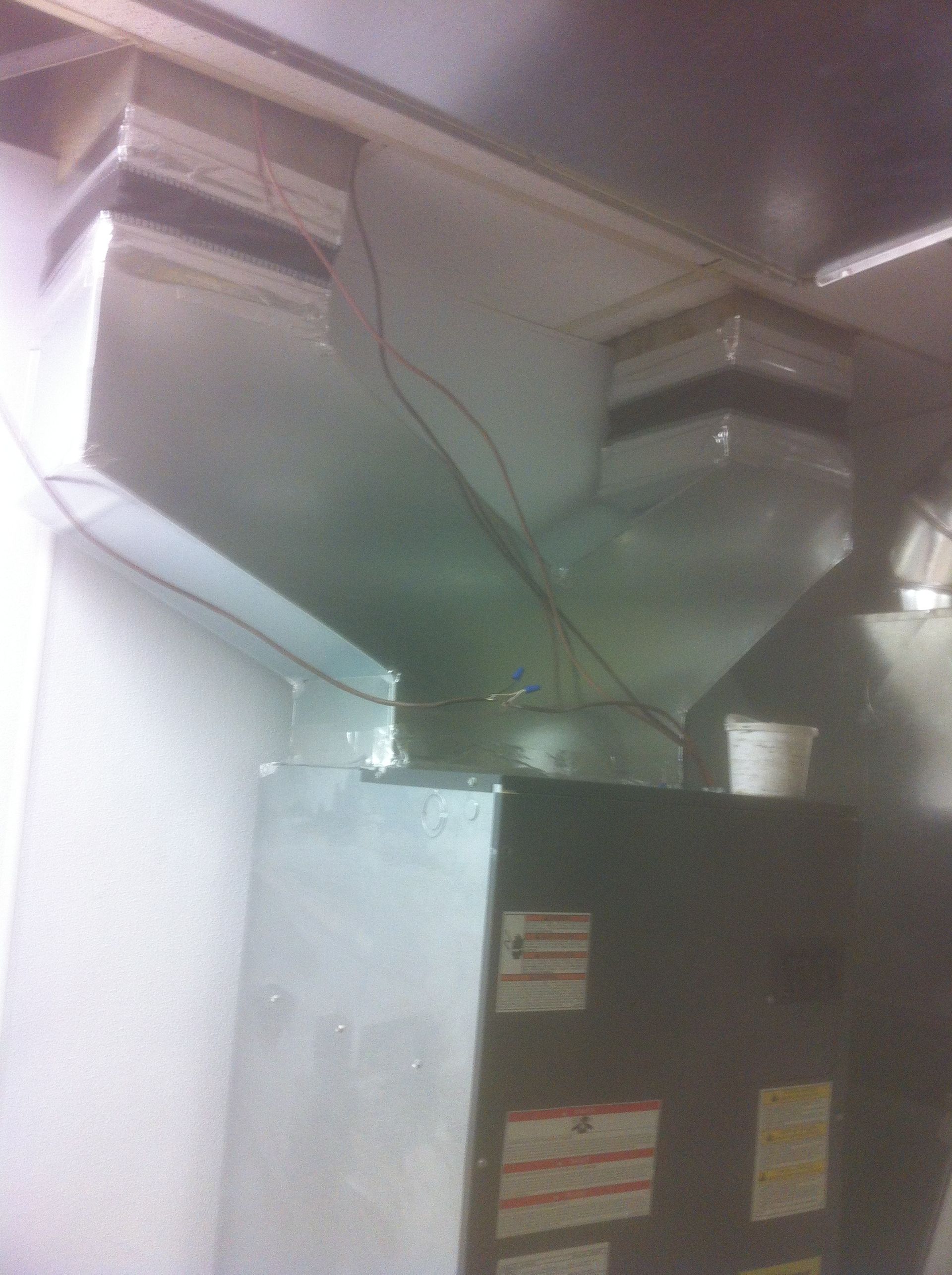 A kitchen with a stove and a ventilation system.