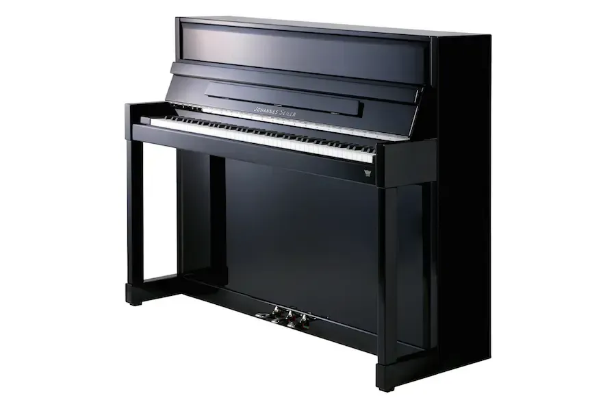 A black upright piano is sitting on a white surface.