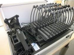 A case open, revealing multiple microphones, connected to electronic equipment.