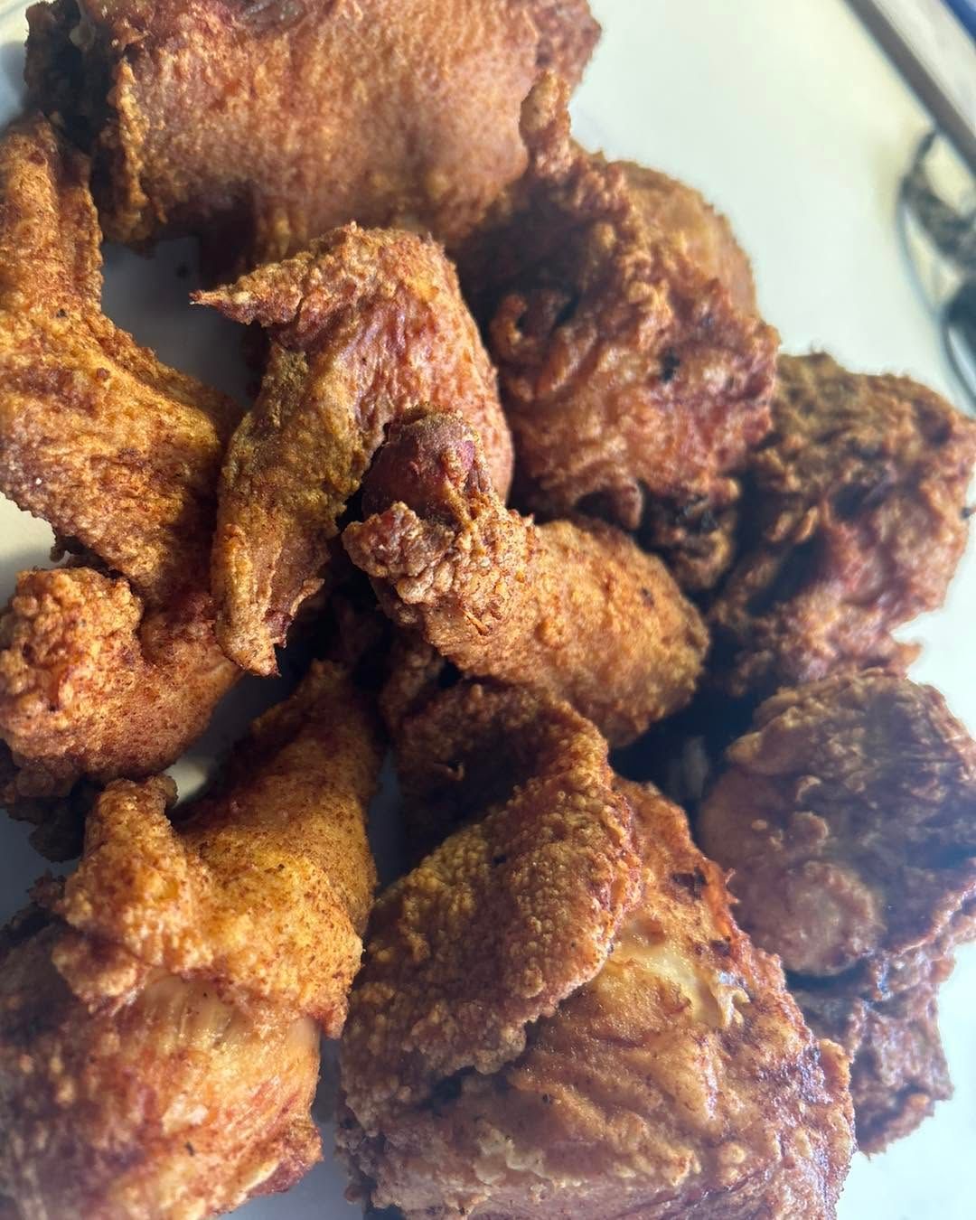 Golden-brown fried chicken pieces piled on a plate
