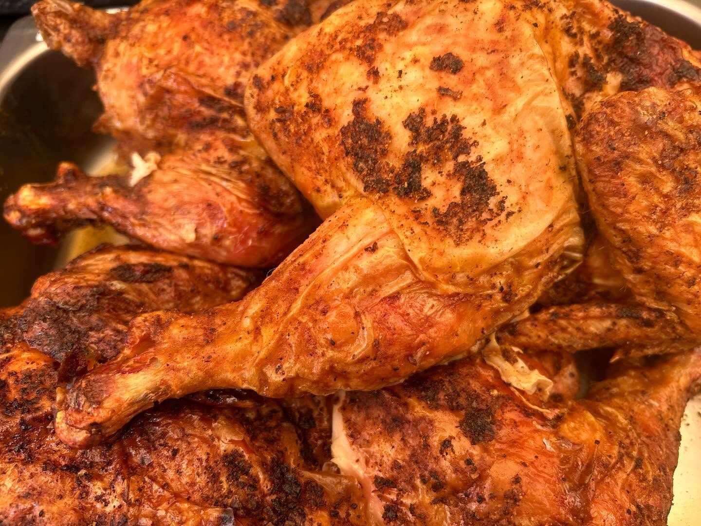 Close-up of roasted chicken pieces with crispy, browned skin on a tray