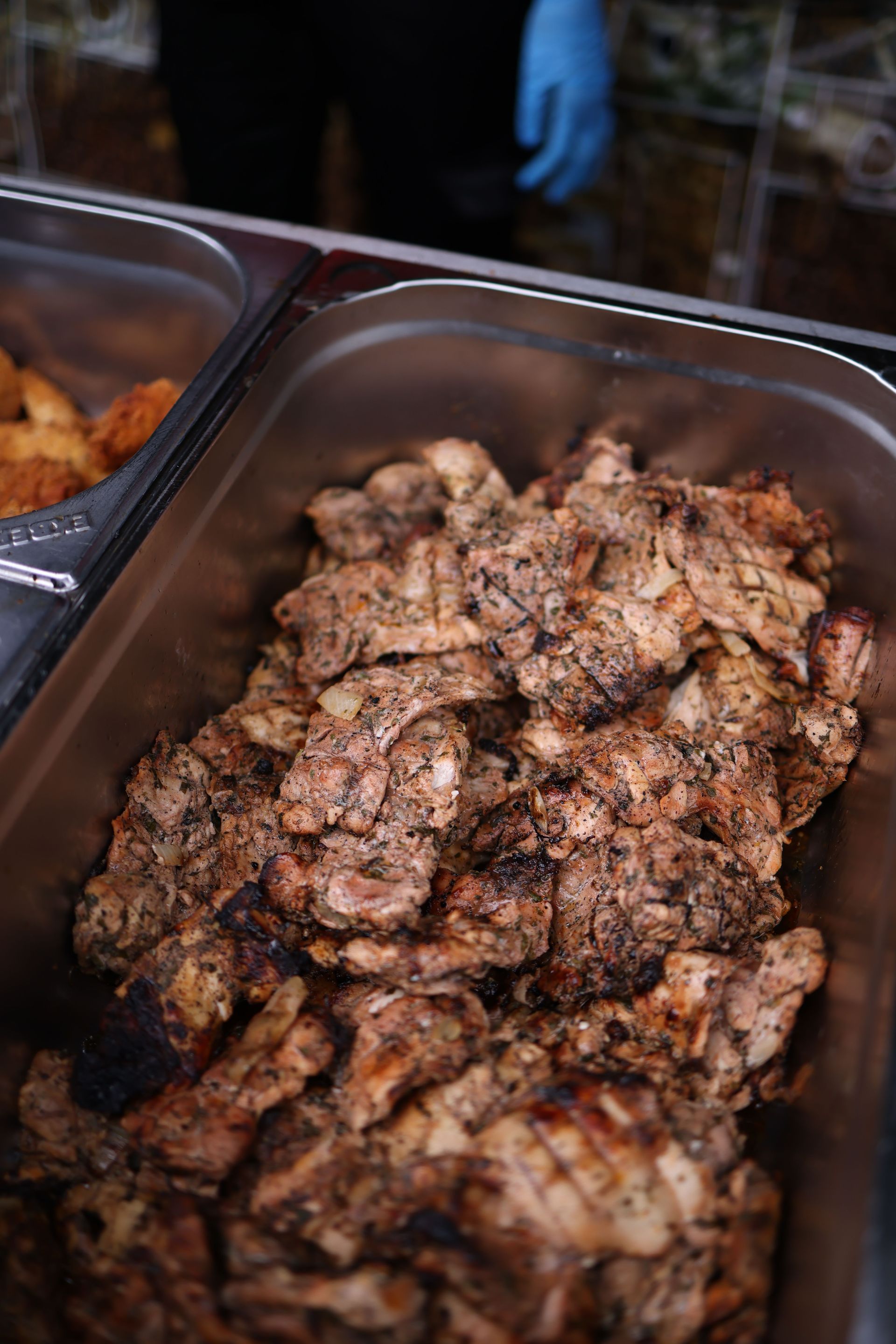 Tray of seasoned grilled meat in a buffet container