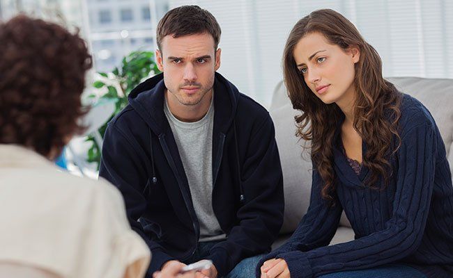 a man and woman talk to someone