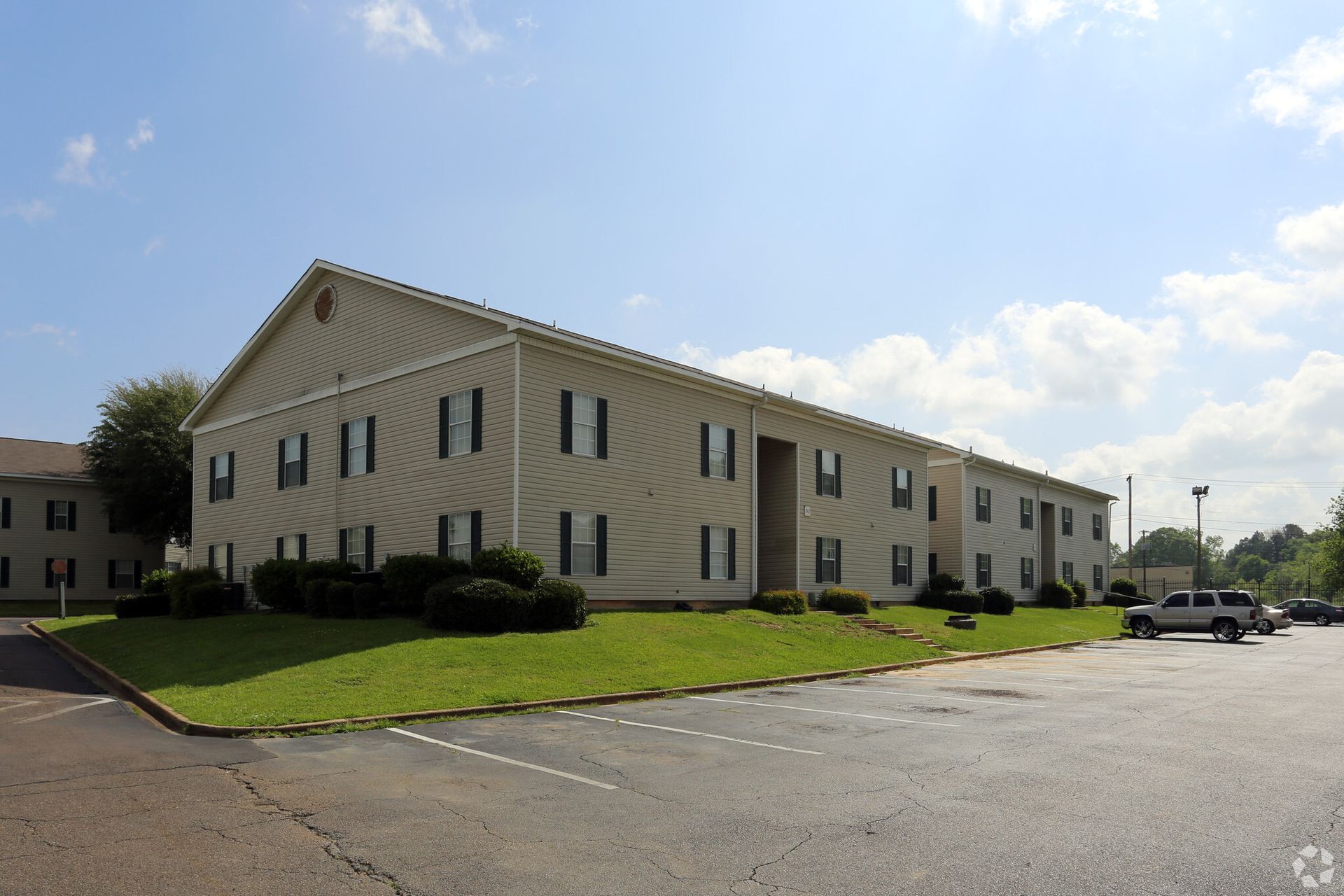 Photo of a long building with a parking lot wrapping around it
