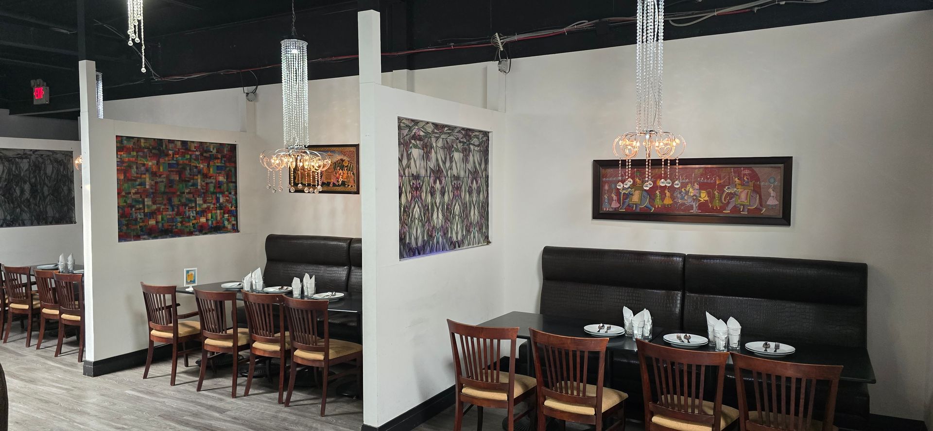 A restaurant with tables and chairs and a chandelier hanging from the ceiling.