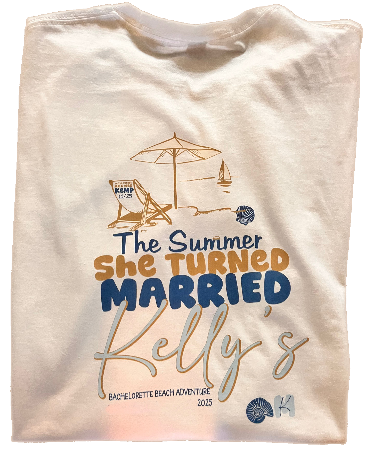 Cream shirt with summer-themed wedding text reading “The Summer She Turned Married Kelly’s” and a beach sketch.