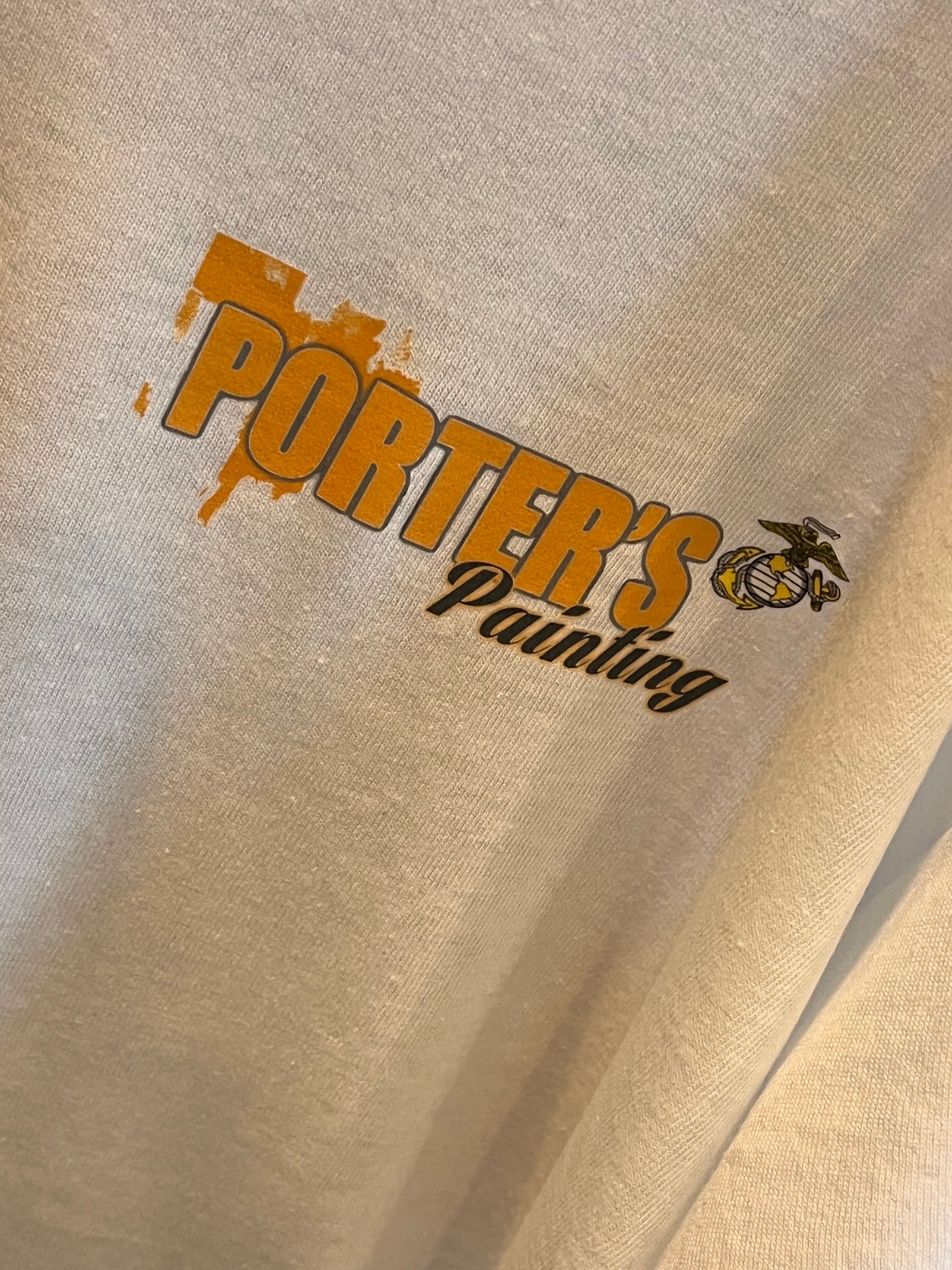 Orange and black Porter’s Painting logo on beige fabric