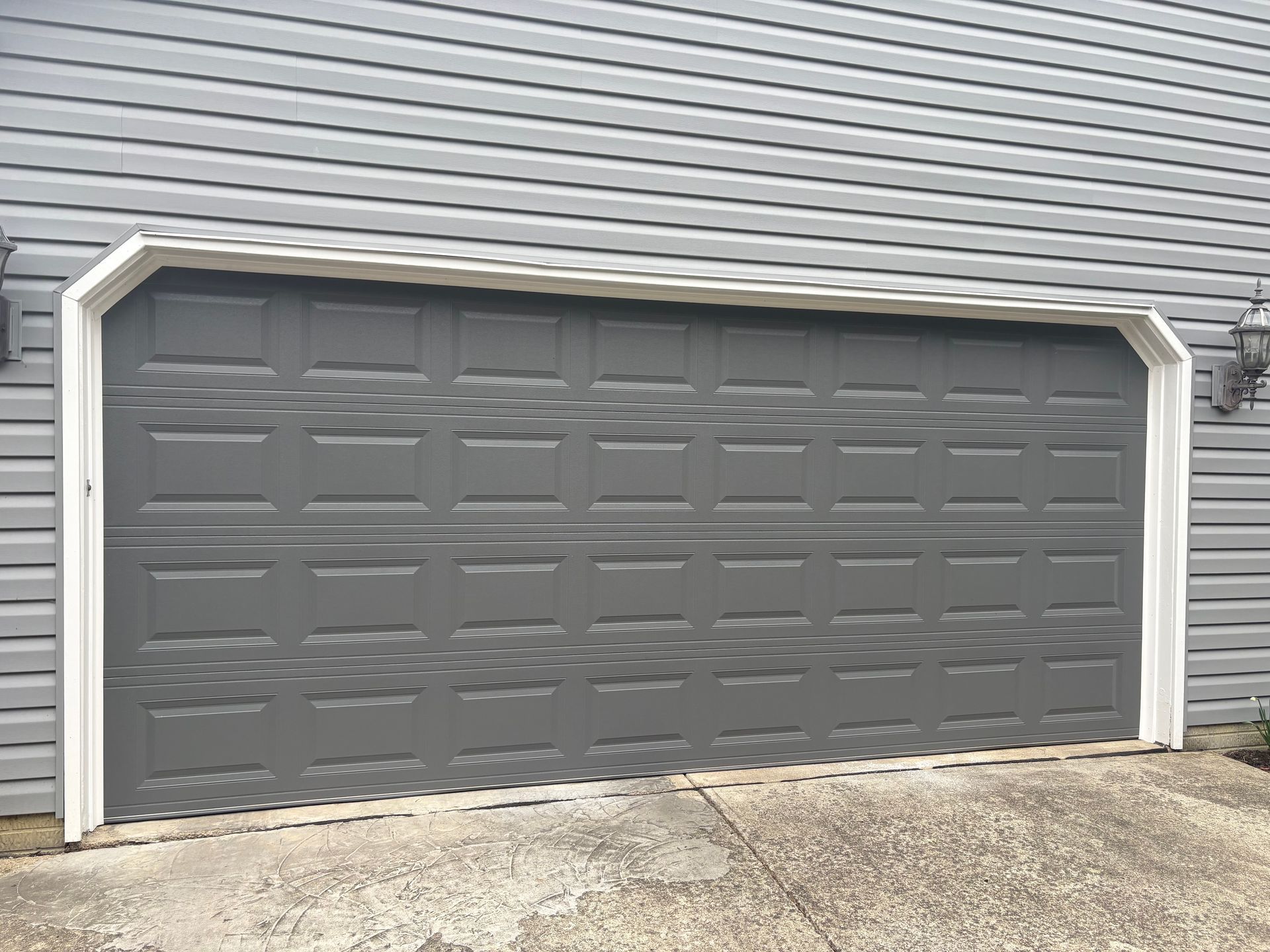 Gray two-car garage door with white trim on a house exterior