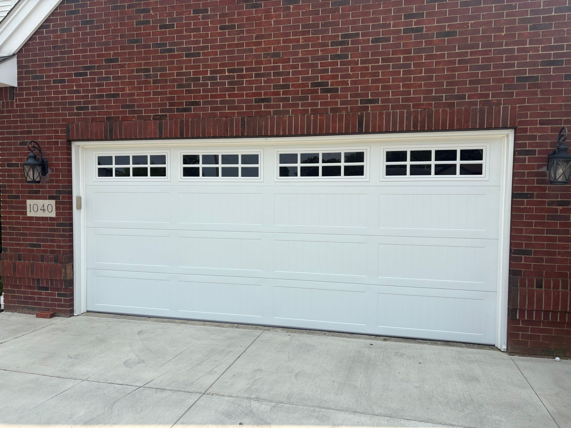 Gray two-car garage door with white trim on a house exterior
