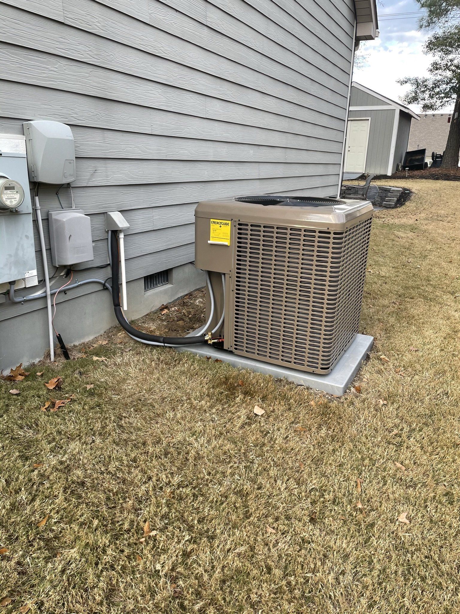 An air conditioner is sitting on the side of a house.