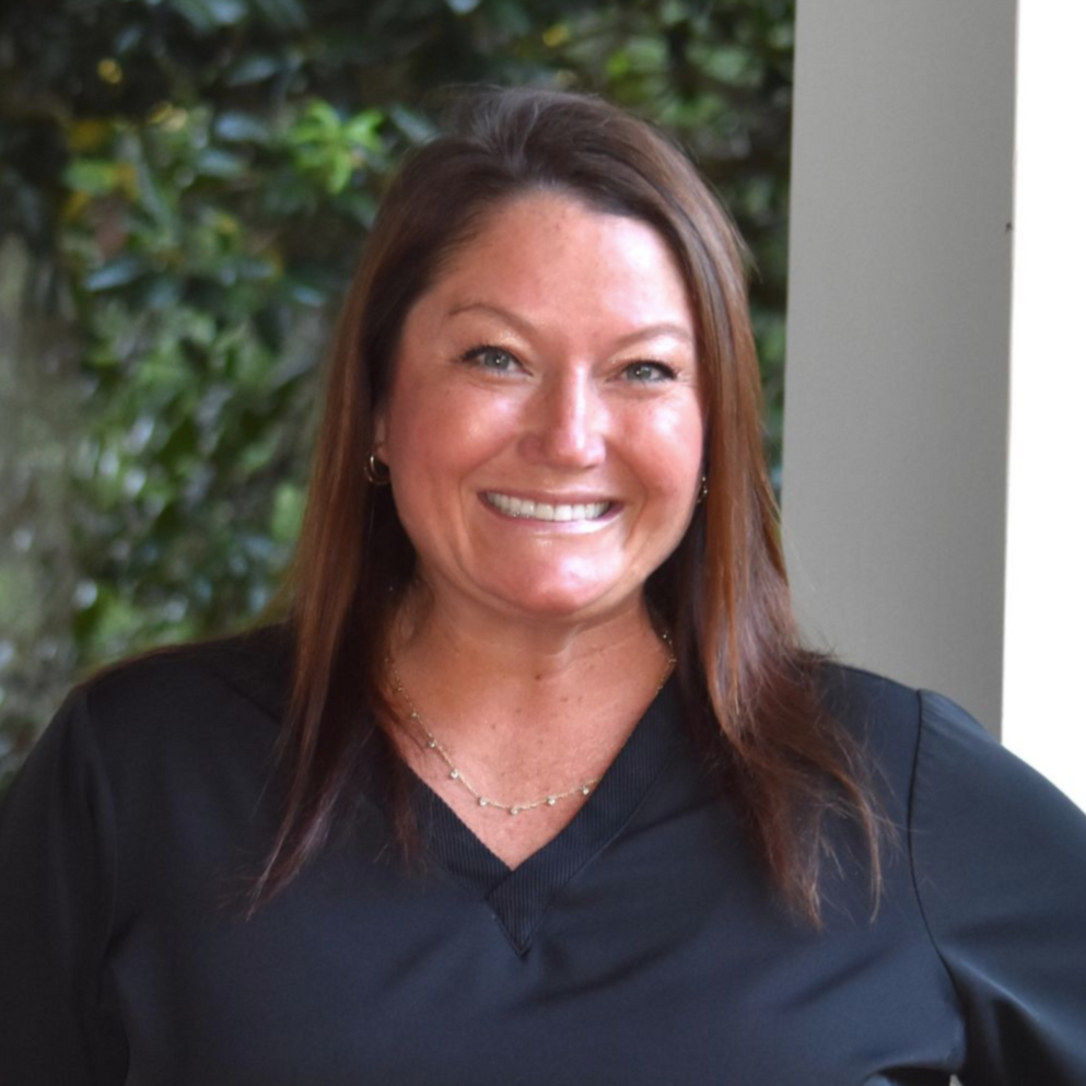 Smiling woman with straight dark hair against a light background