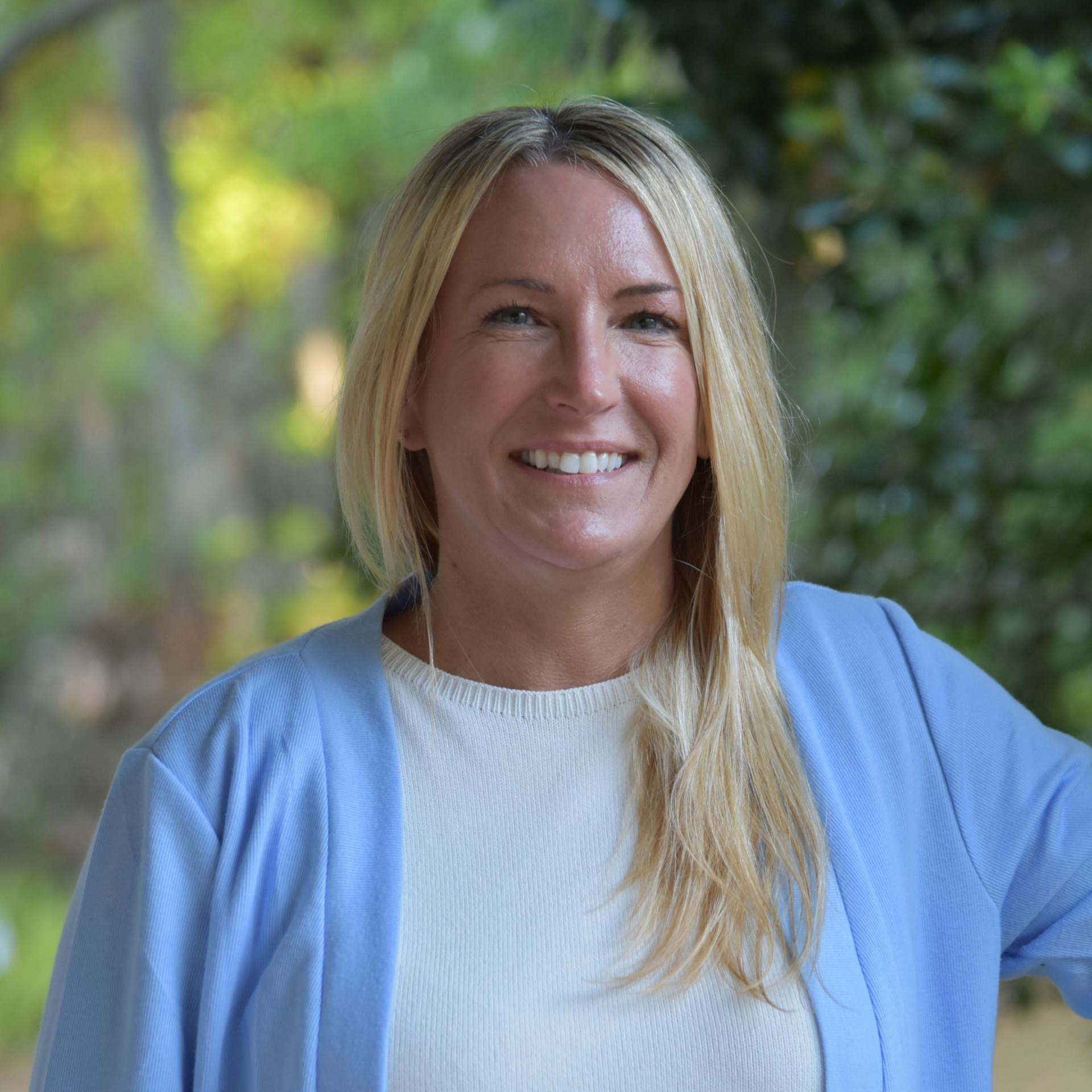 Portrait of a smiling blonde woman against a light background