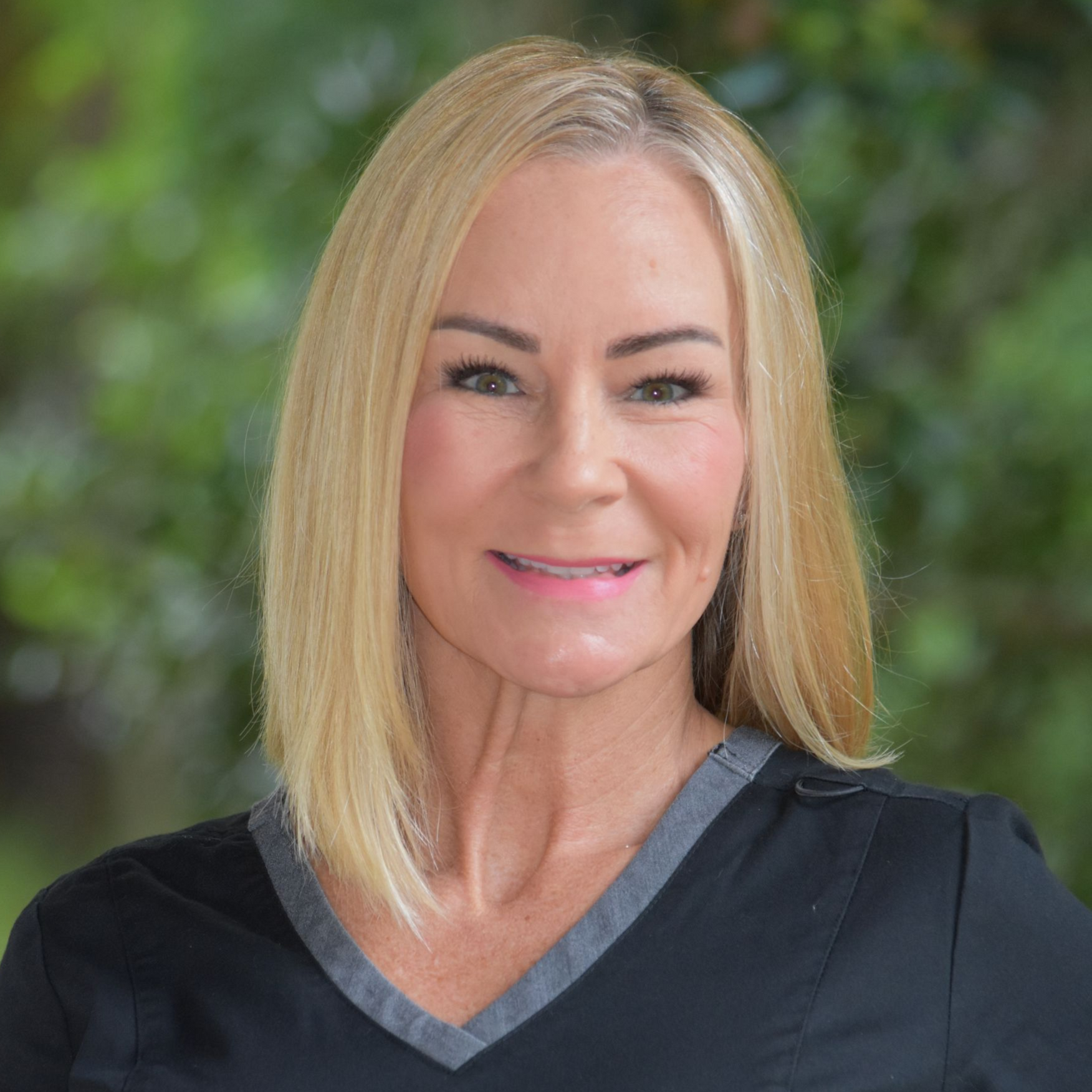 Portrait of a smiling blonde woman against a white background
