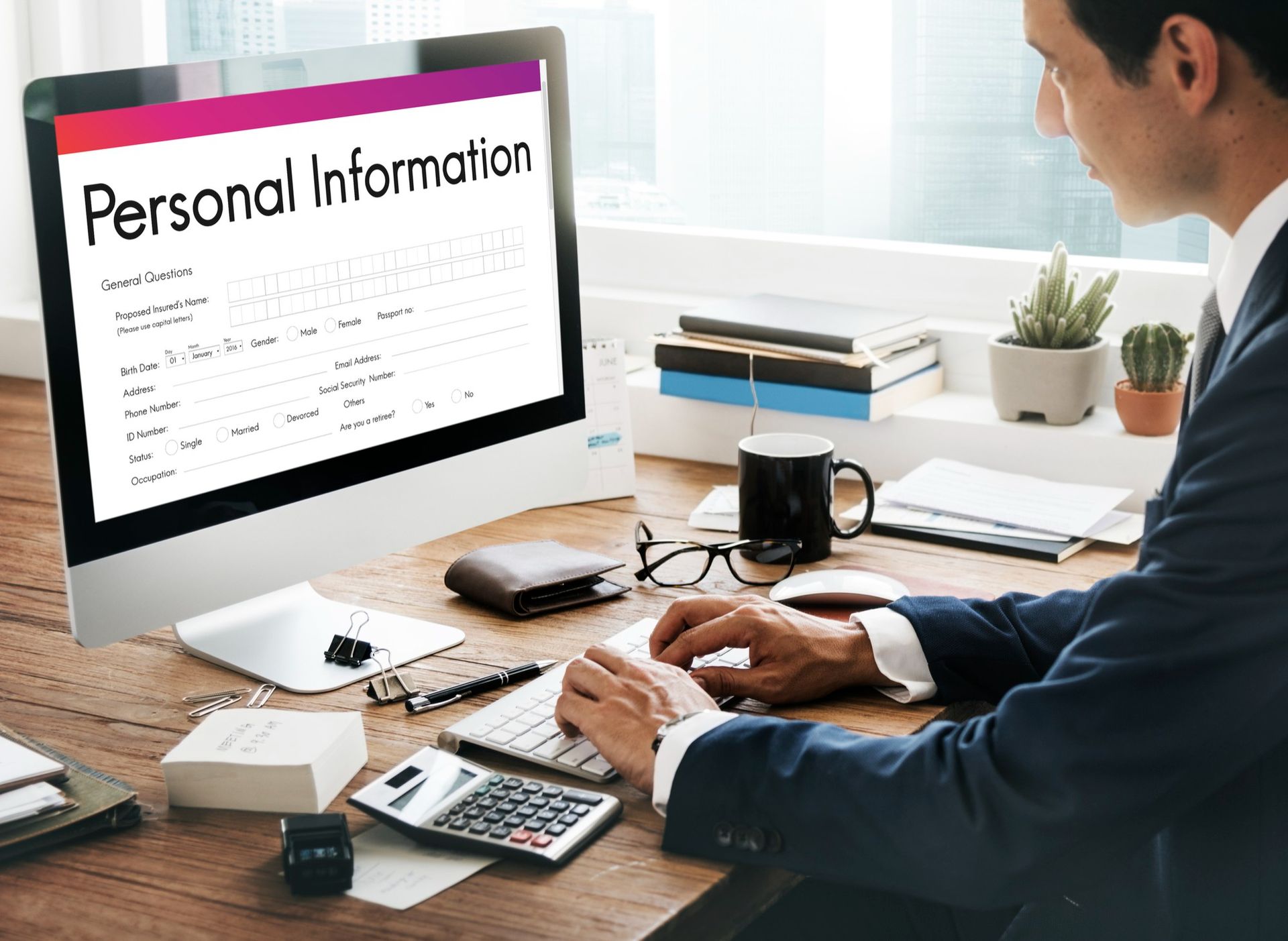 Man at desk reviewing personal information on a computer in a bright office