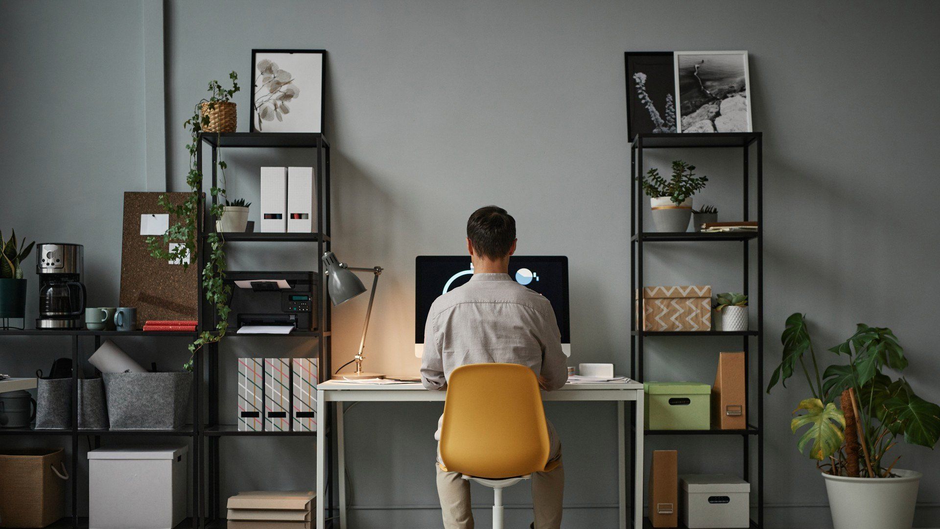 A man is sitting at a desk in front of a computer.