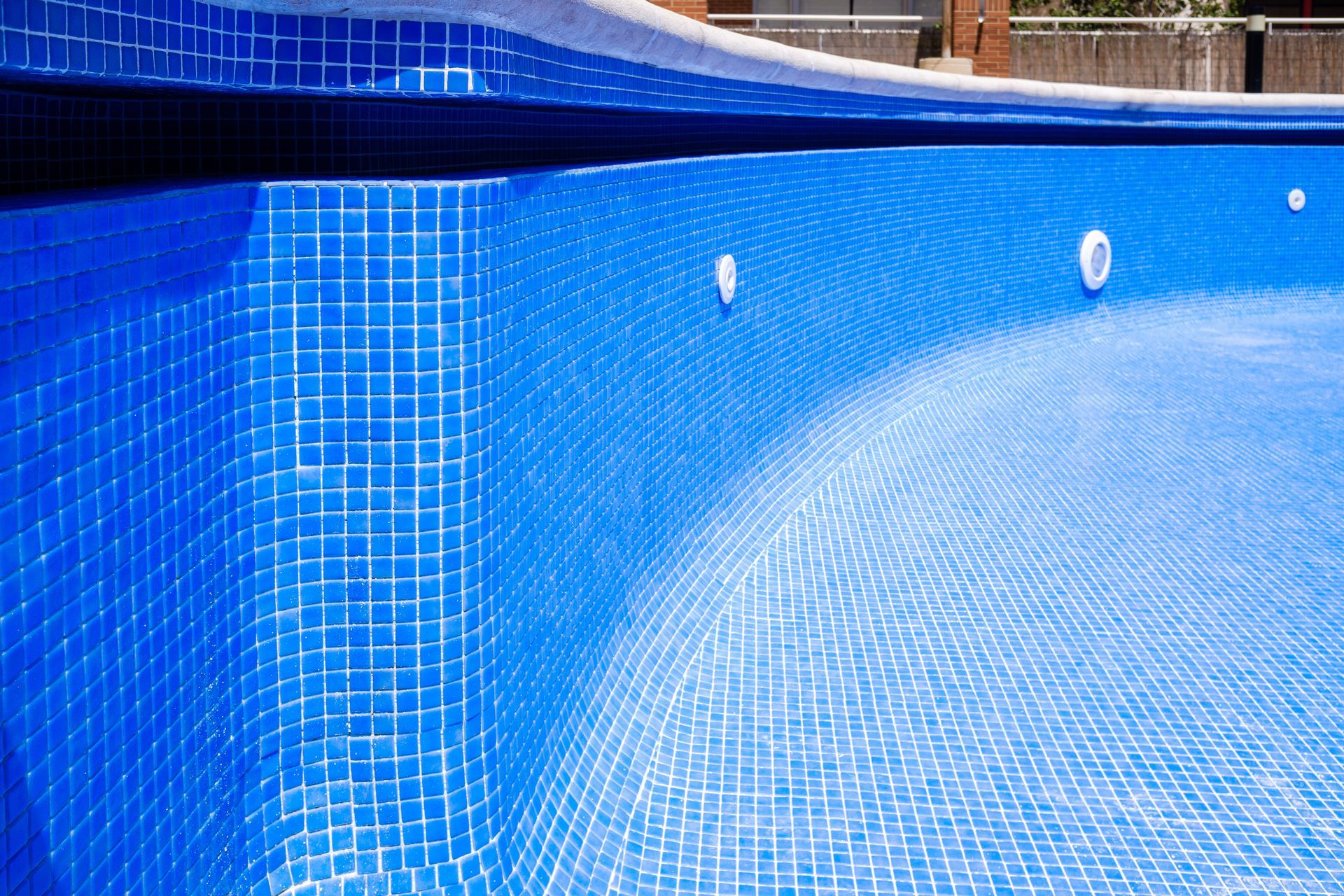 Empty swimming pool lined with blue mosaic tiles. Empty swimming pool lined with blue mosaic tiles.