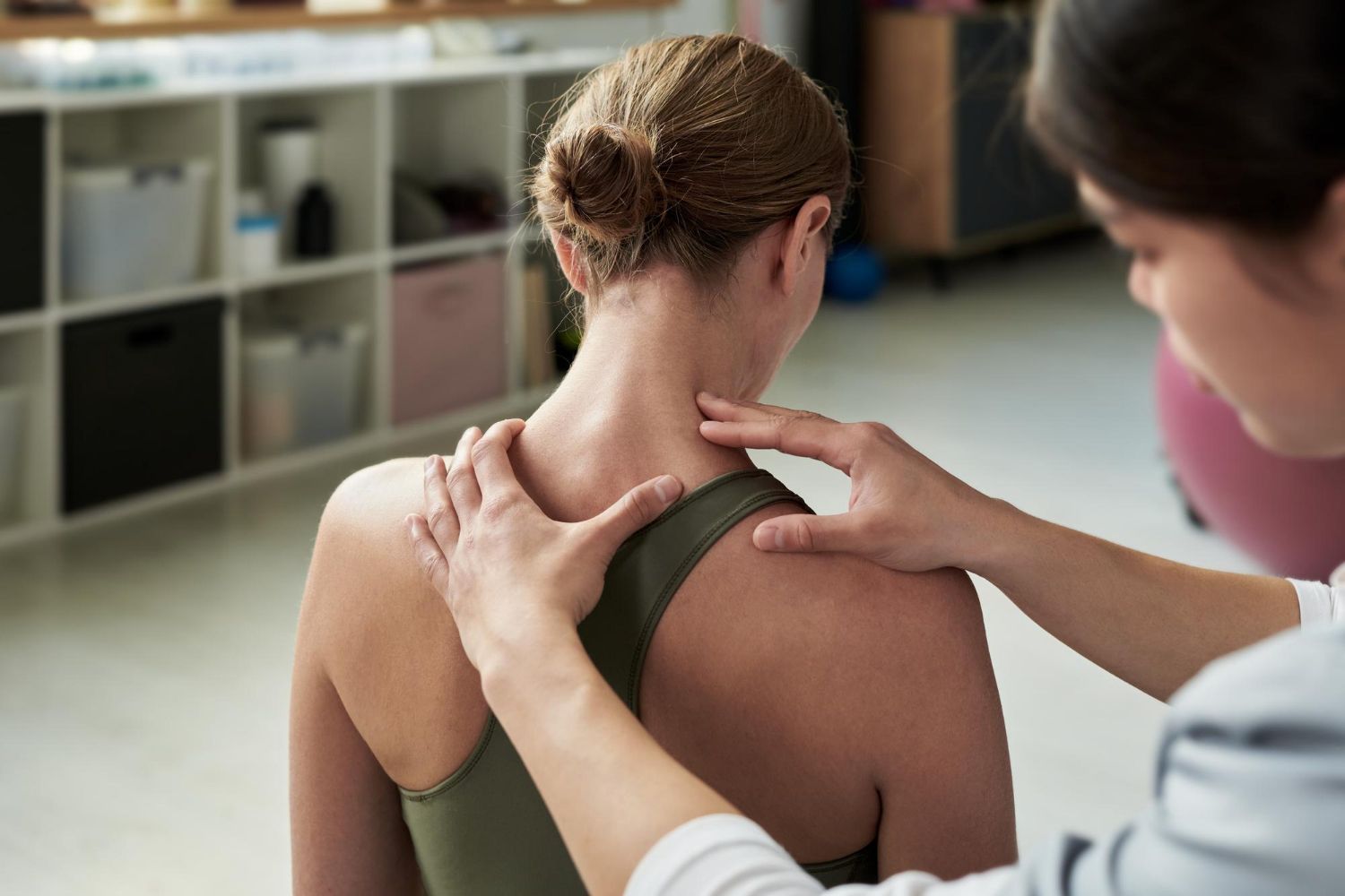 Physical therapist examining a patient’s shoulder in a clinic setting