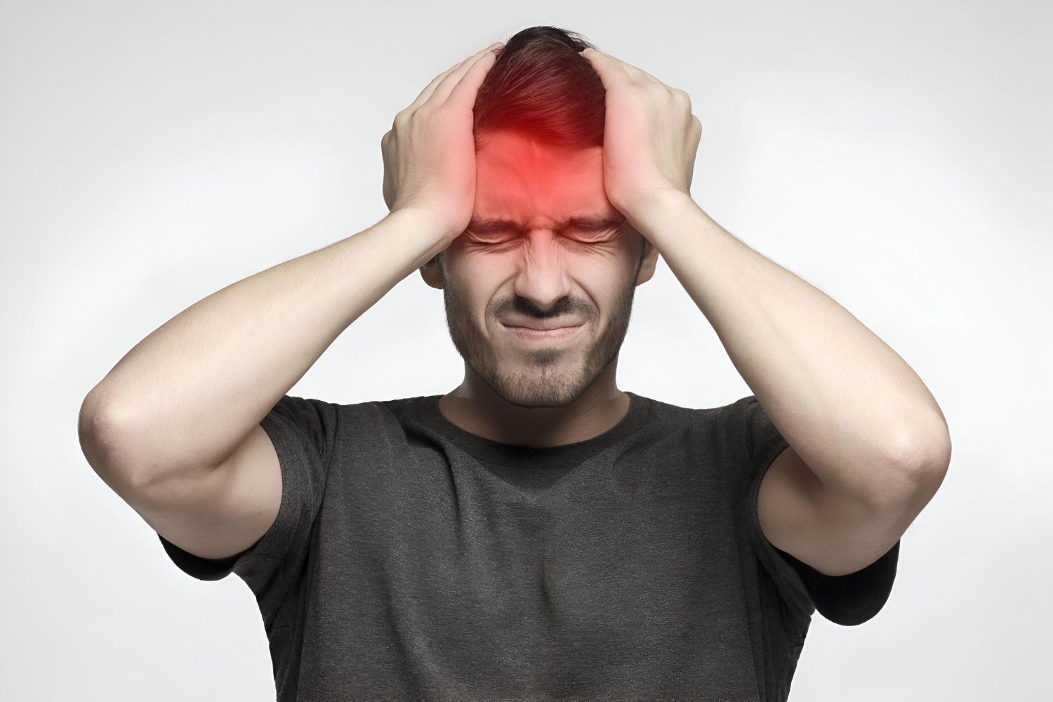 Man clutching his head in pain, with a red glowing forehead on a plain background