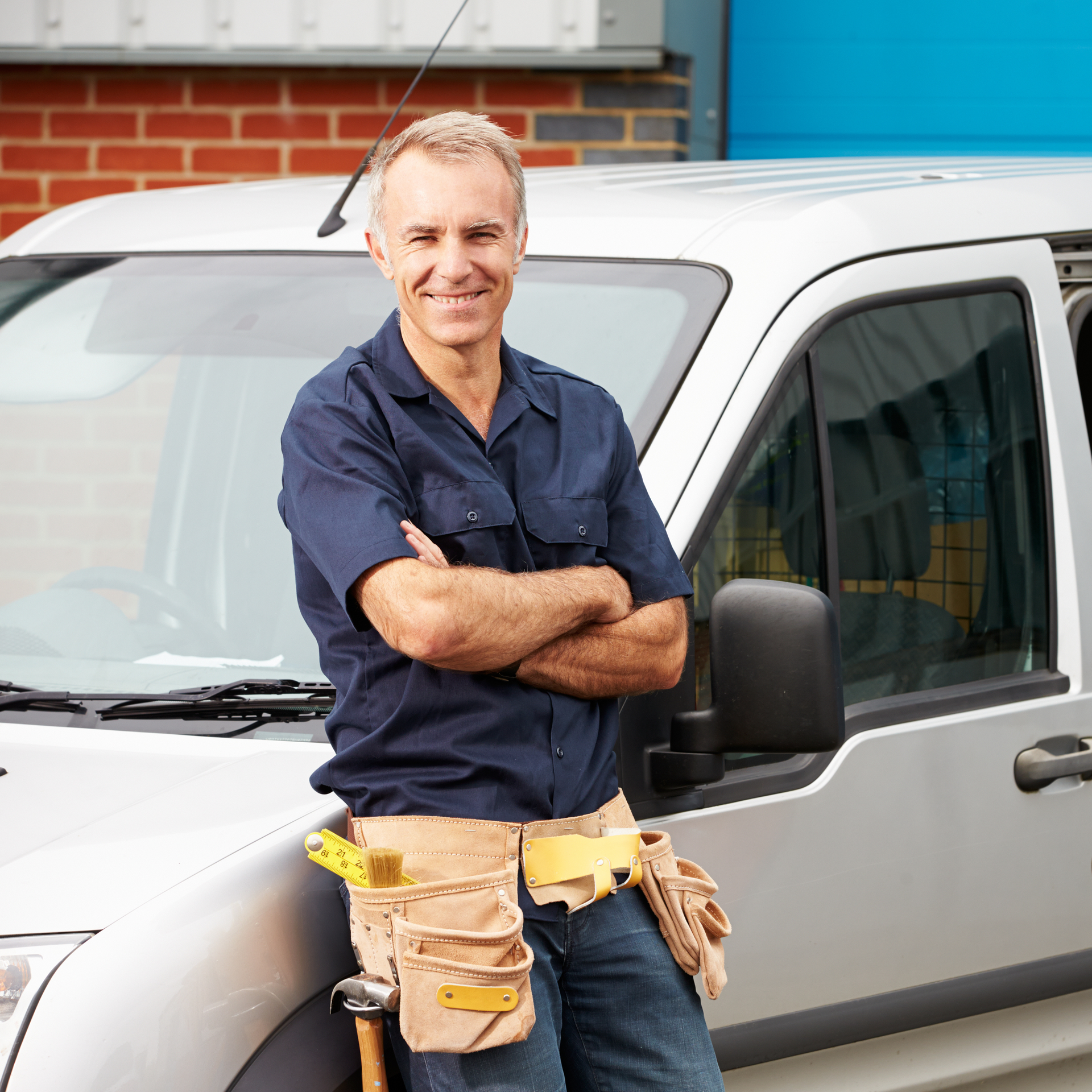 a man leaning against a van with his arms crossed